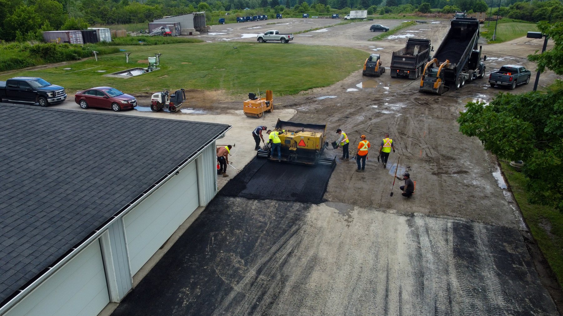 Aerial construction progress view with paving crew and equipment