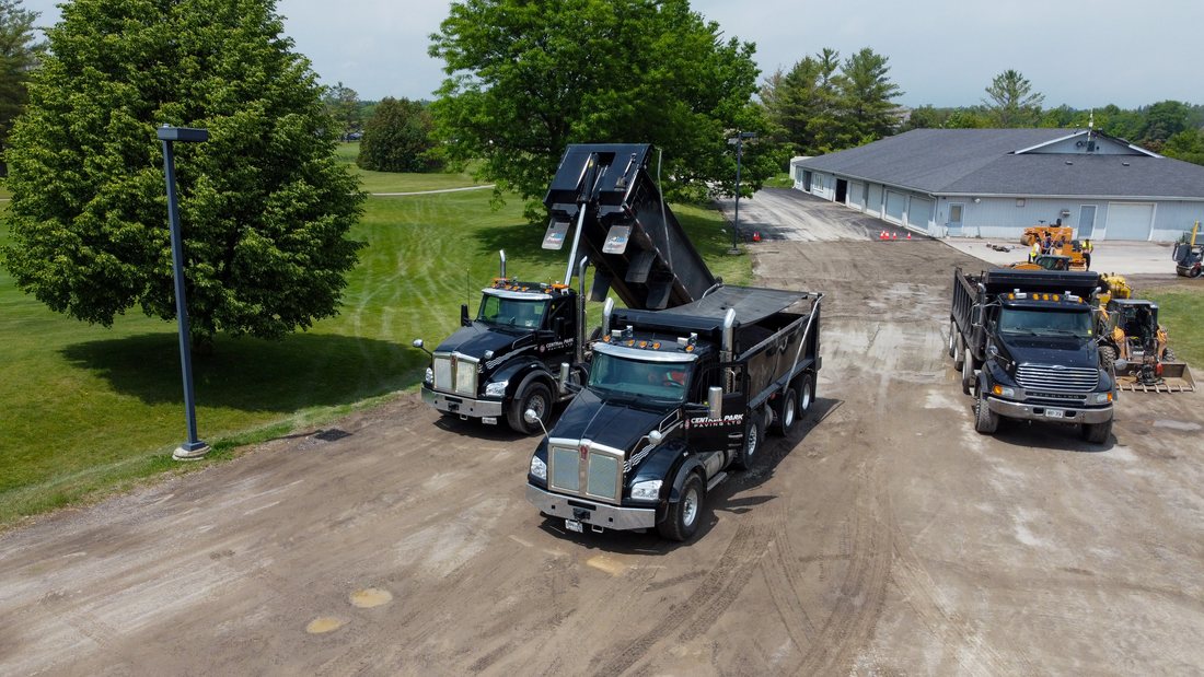 Construction trucks and equipment staged near building exterior